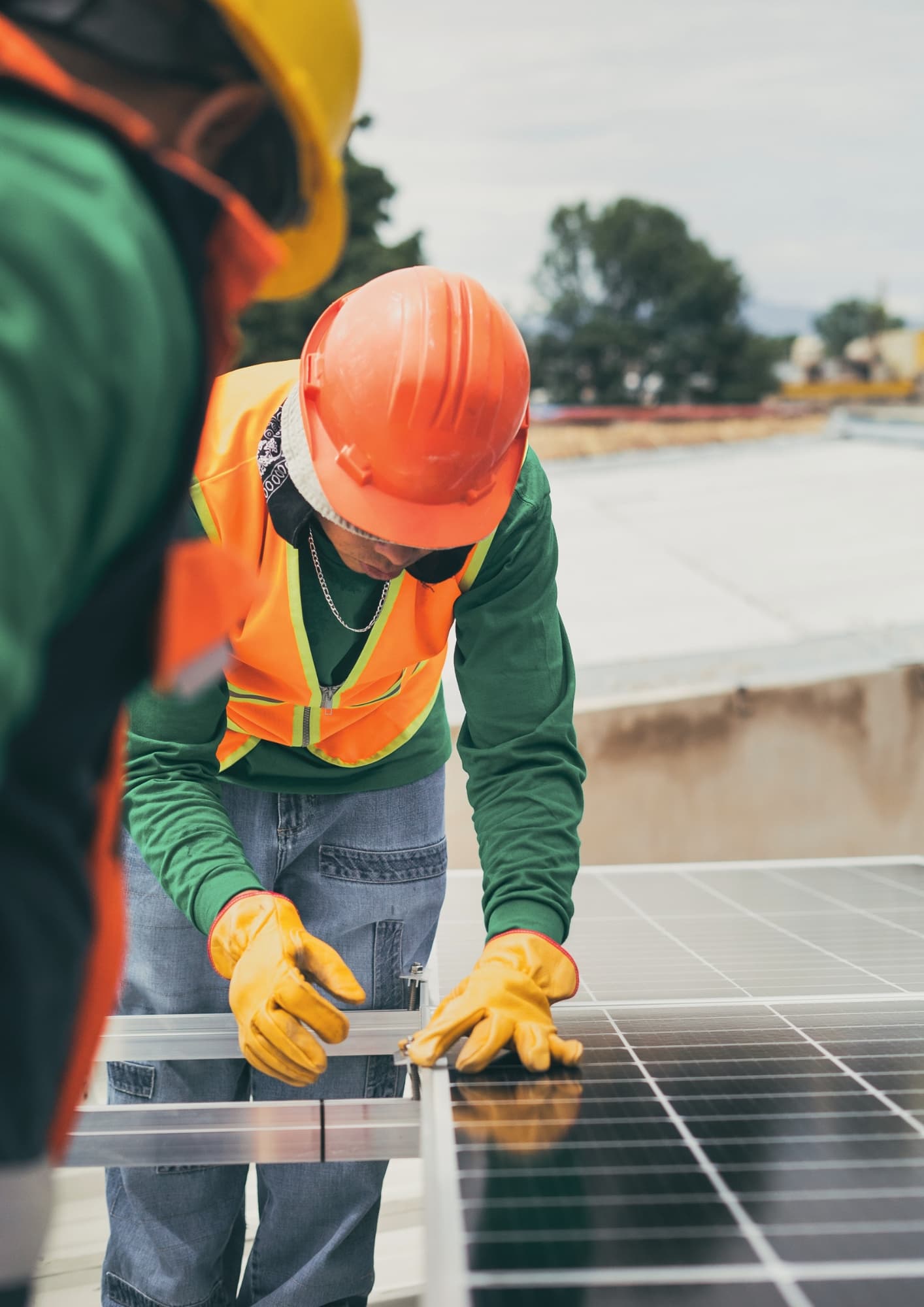 Technicien casqué fixant un panneau solaire sur une toiture